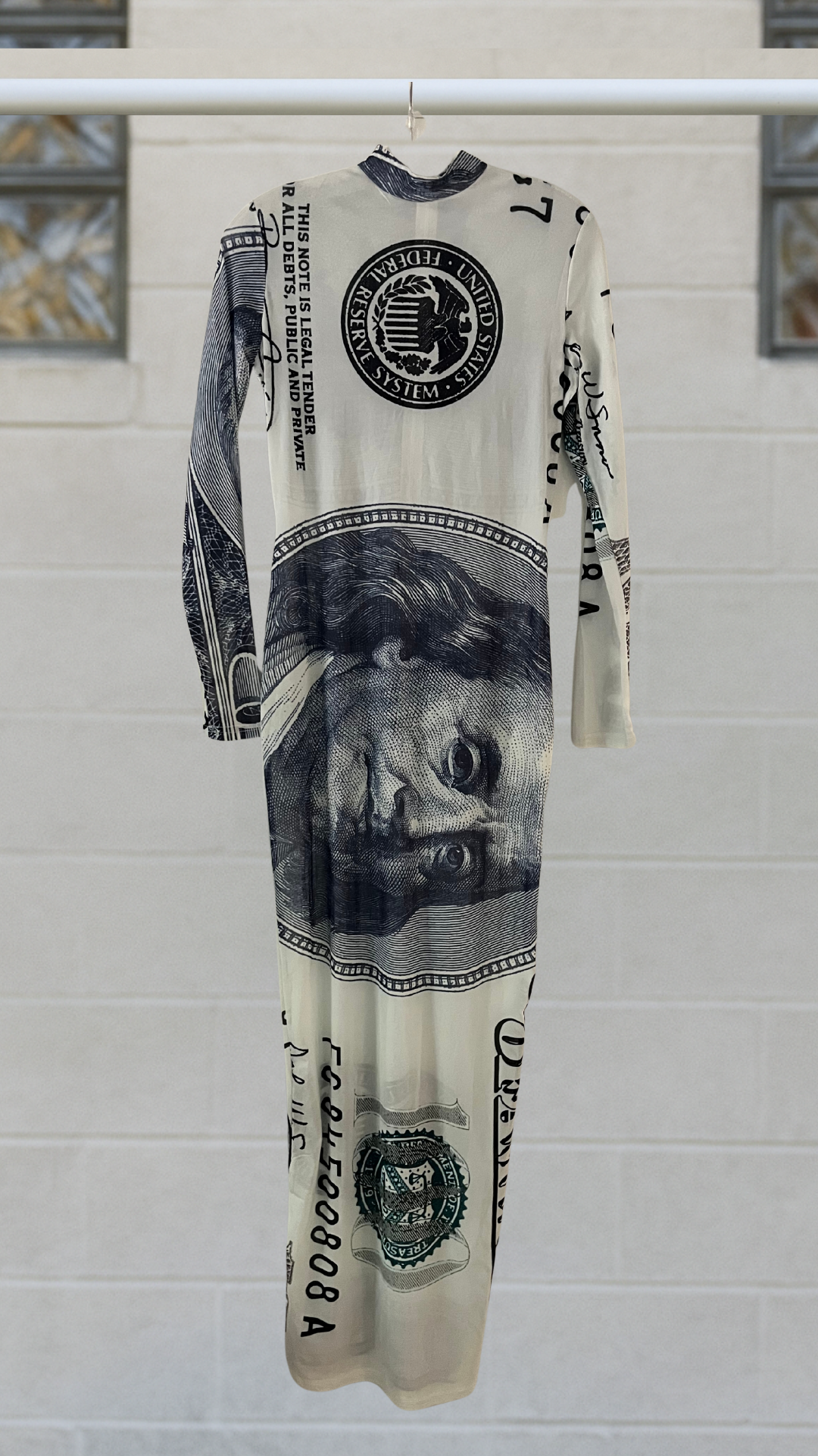 a long maxi dress with a dollar bill fabric on a hanger against a white background