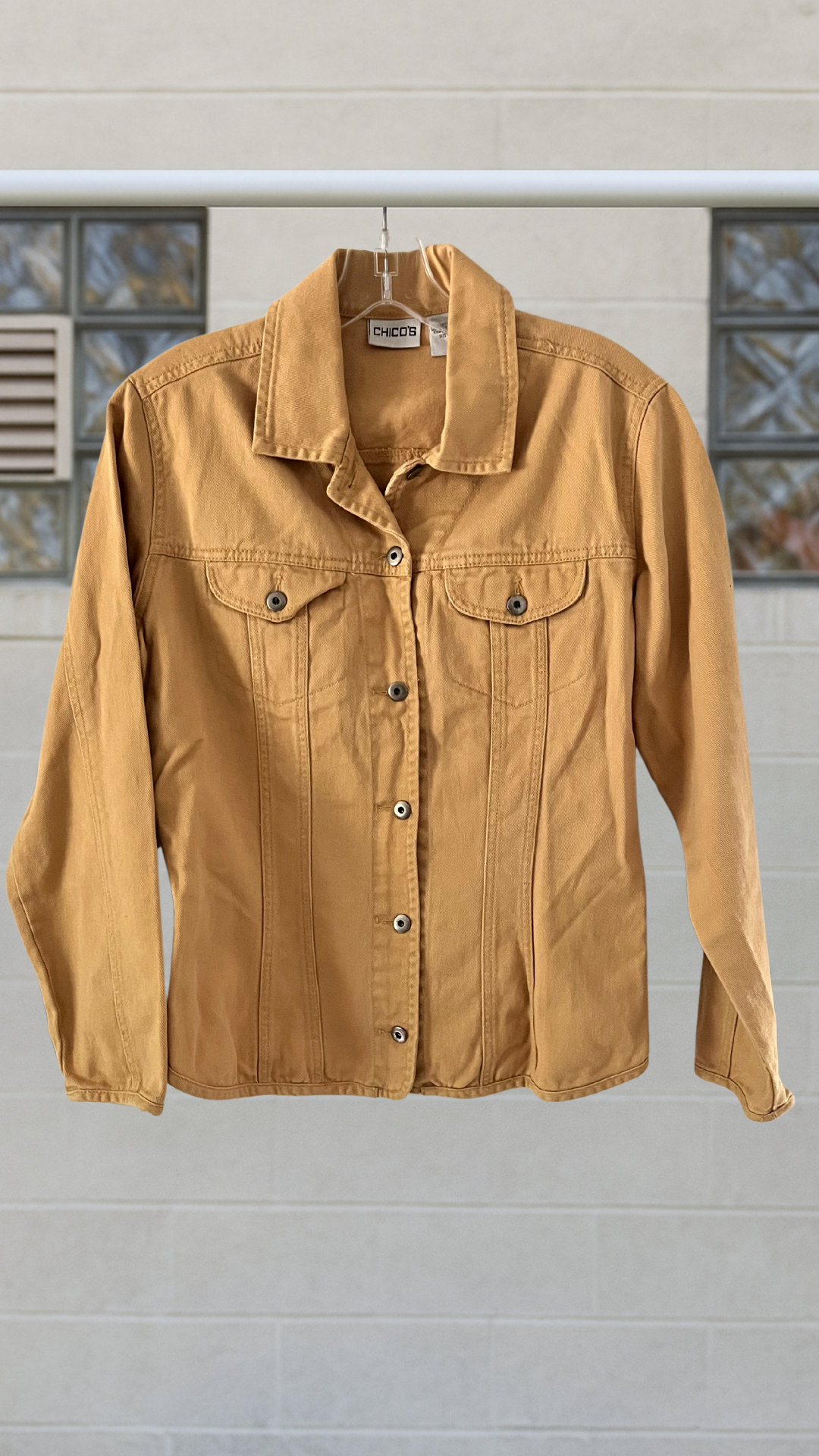 a yellow tailored denim jacket on a hanger against a white background