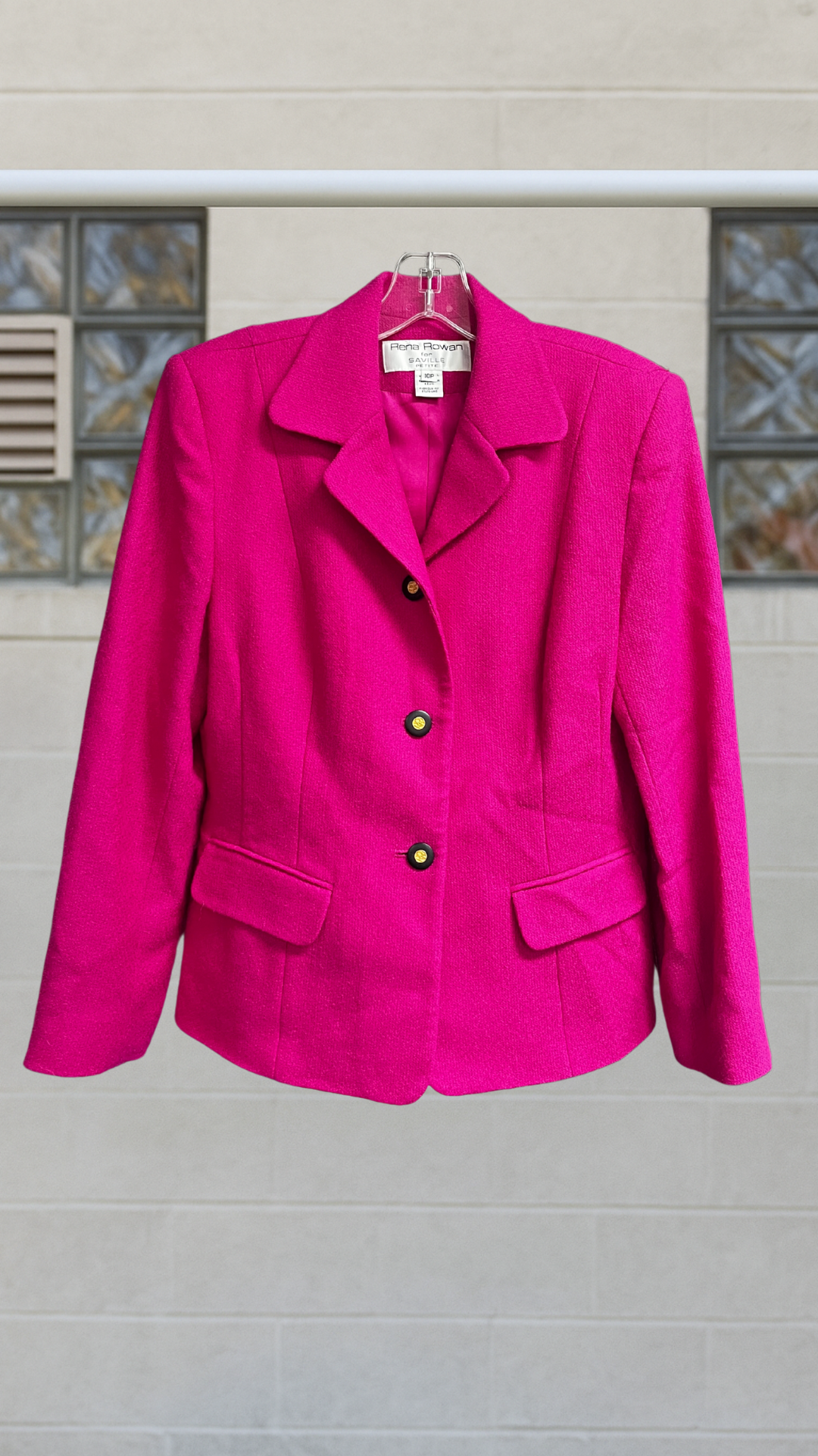 a hot pink blazer on a hanger against a white background 
