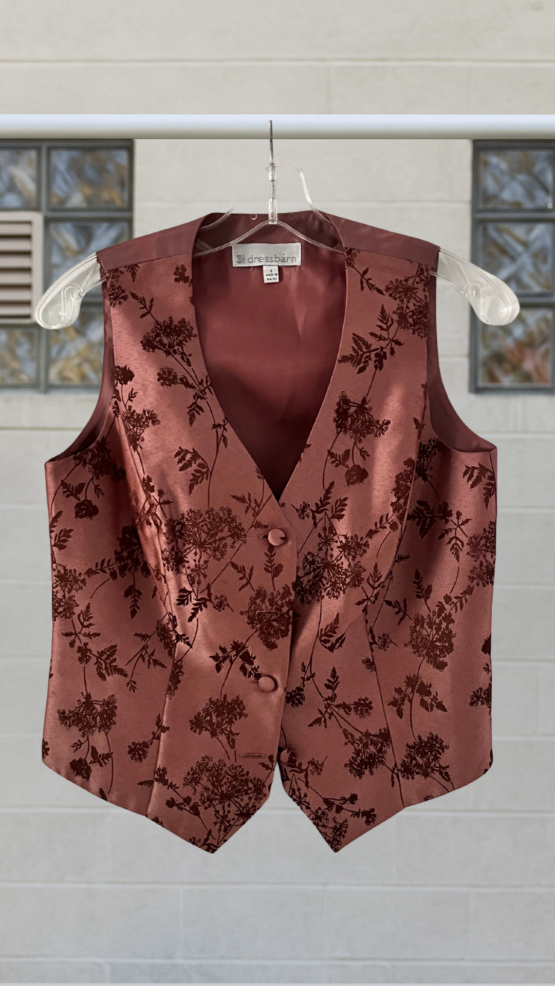 a purple vest with satin sheen on an hanger against a white background