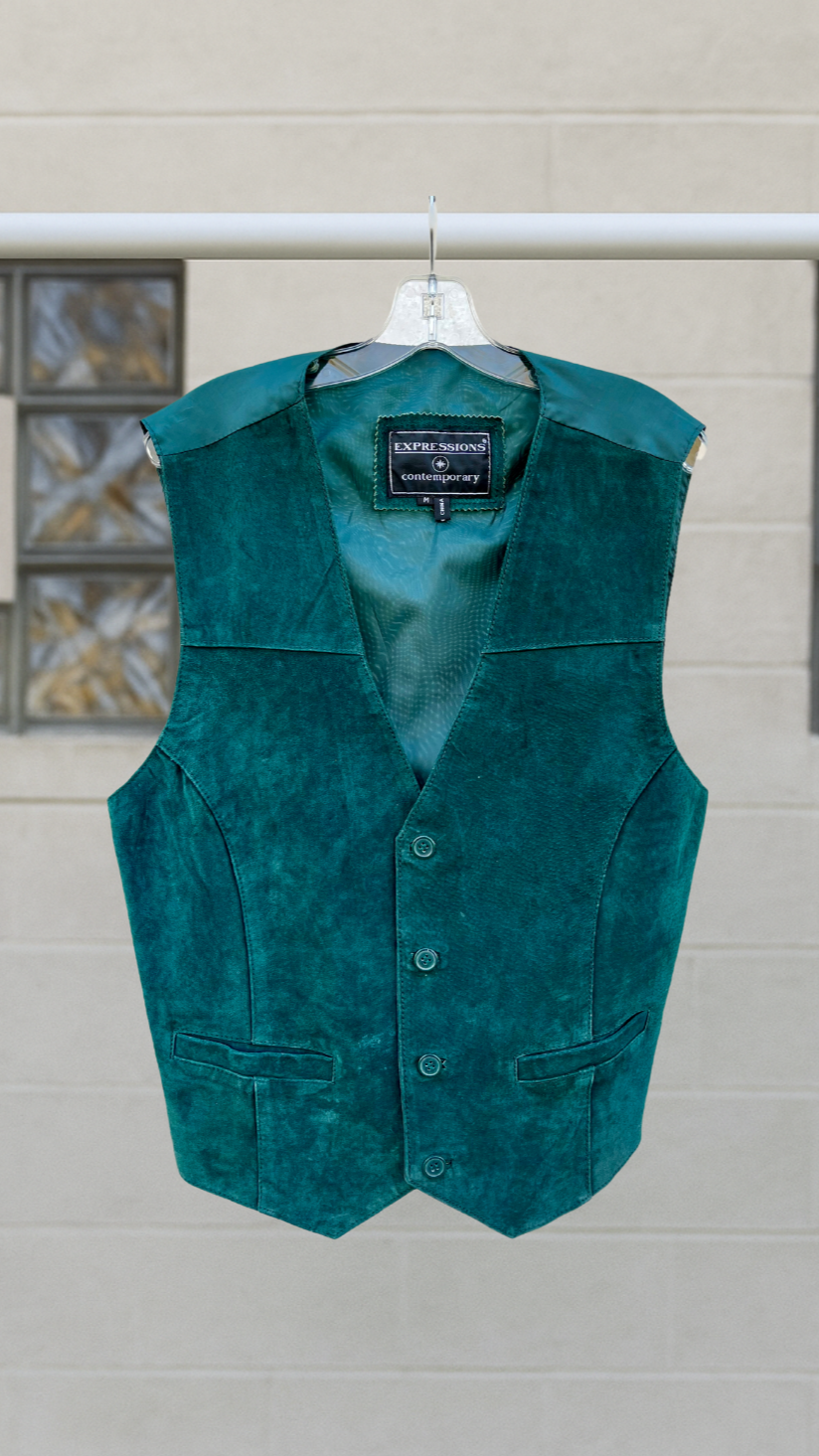 a teal leather vest on a hanger against a white background