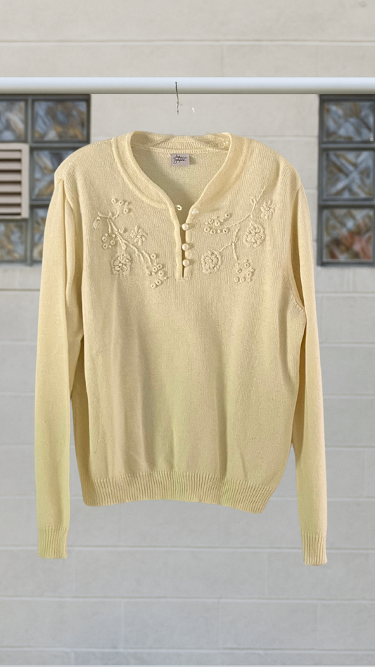 Cream sweater with floral embroidery on a white background