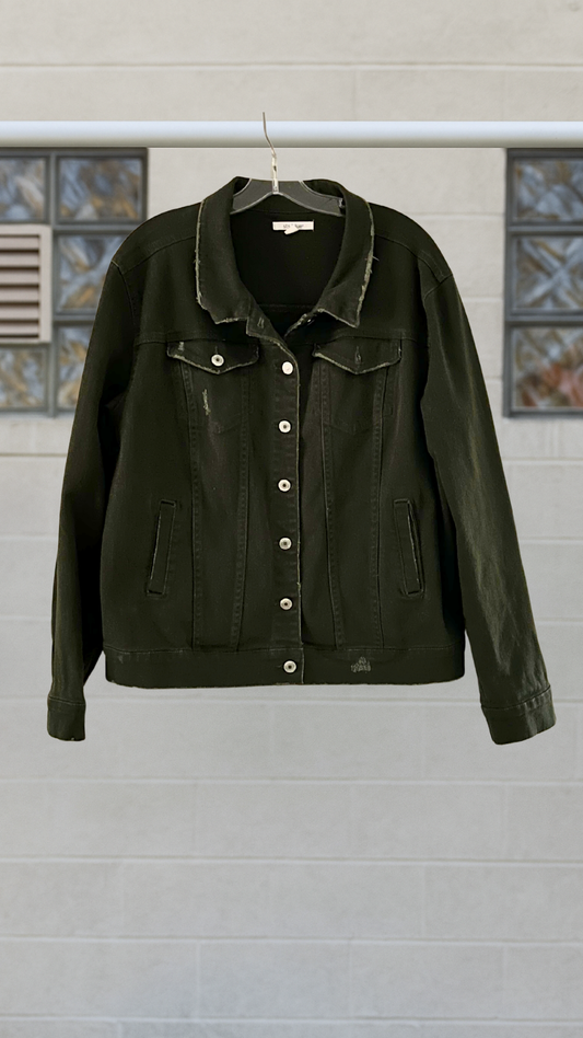 a green denim jacket on a hanger against a white wall