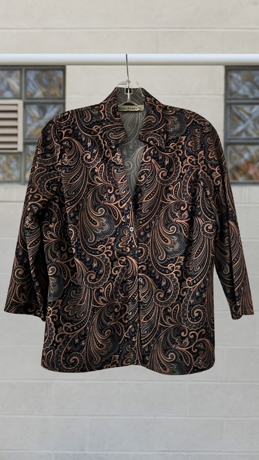 Patterned shirt on a hanger against a light-colored wall with decorative elements.