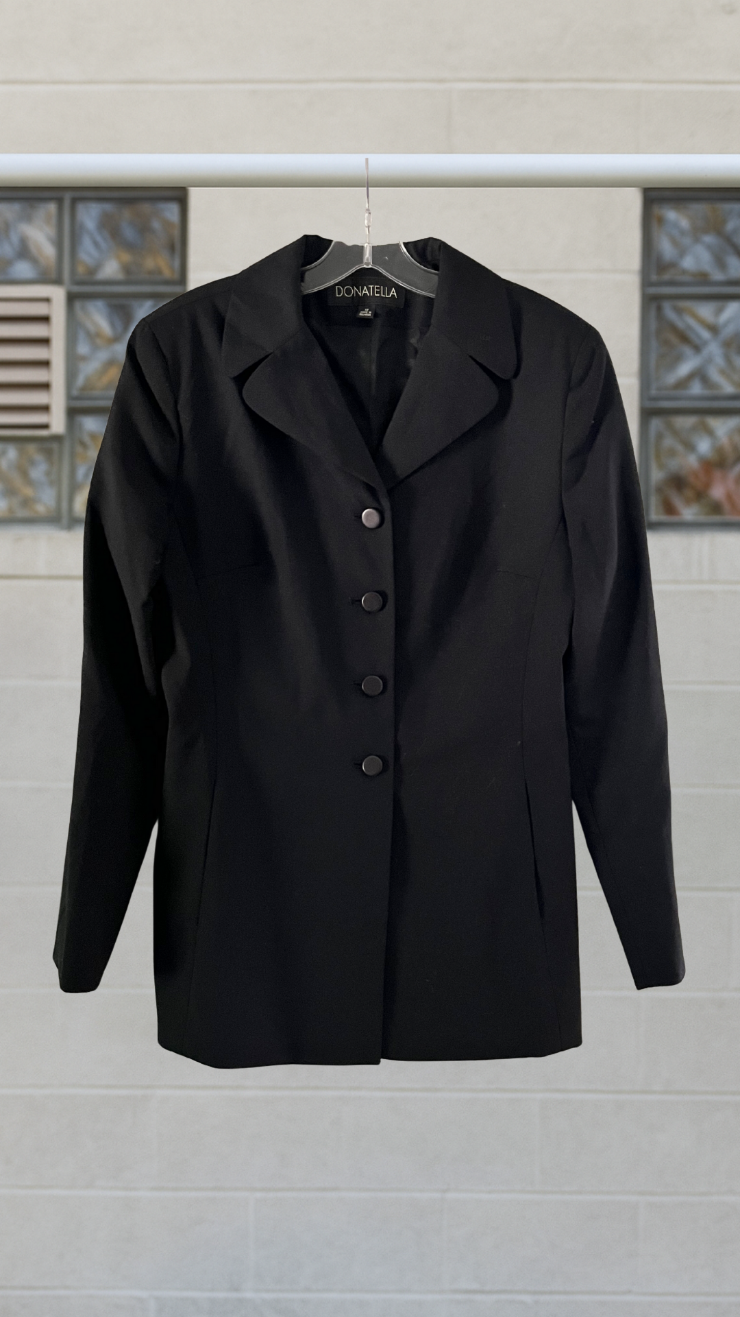 A black wool blazer jacket with notched lapel and front button closure
