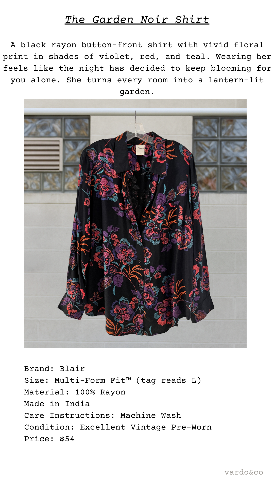 Black rayon shirt with floral print on a hanger against a tiled wall.