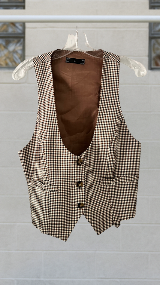 Houndstooth patterned vest with brown interior on a hanger against a light gray background