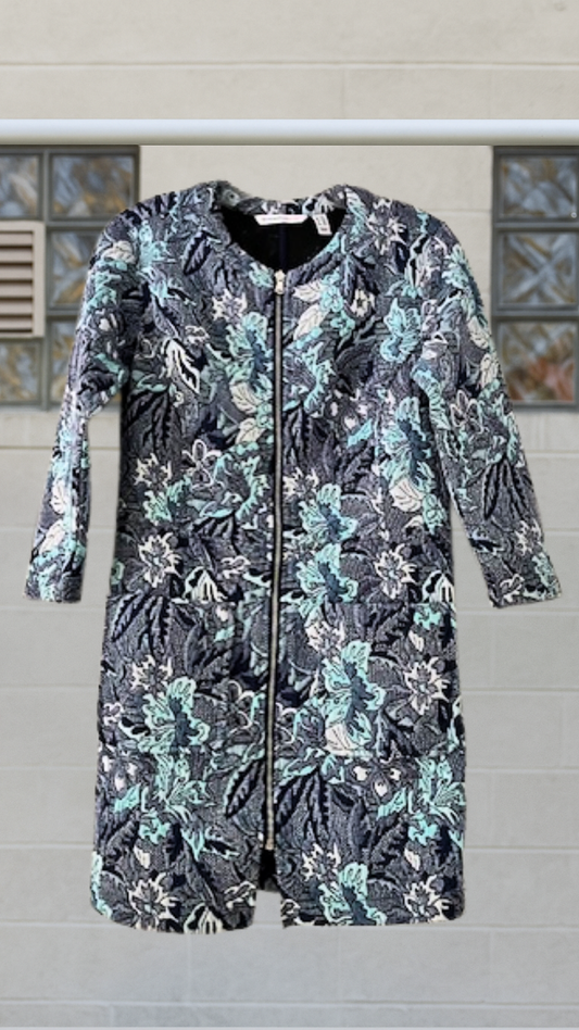 Long floral zip-up jacket in moody blues and greens with three-quarter sleeves and deep pockets, displayed on hanger against light wall.
