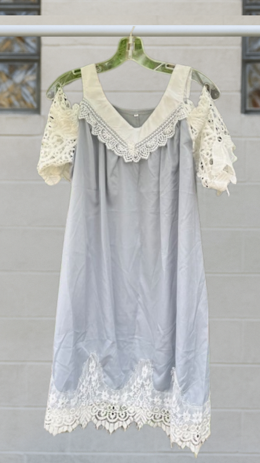 Pale gray off-the-shoulder tunic with ivory lace sleeves, scalloped hem, and oversized drape, displayed on hanger.
