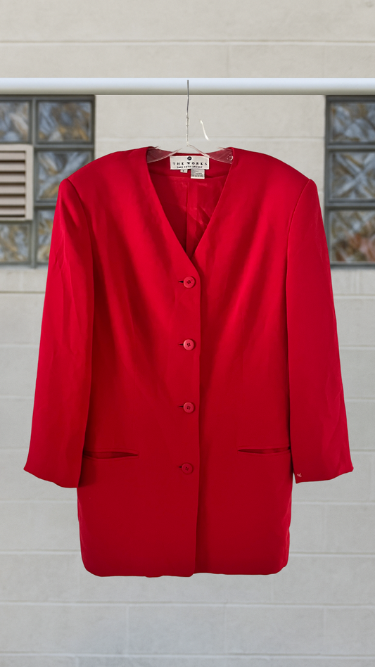 Red blazer on a hanger against a neutral background