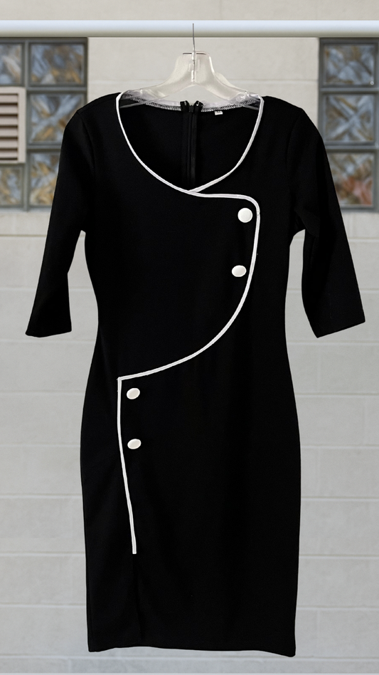 Black fitted sheath dress with asymmetrical white piping, oversized decorative buttons, and three-quarter sleeves, displayed front-on against light backdrop.
