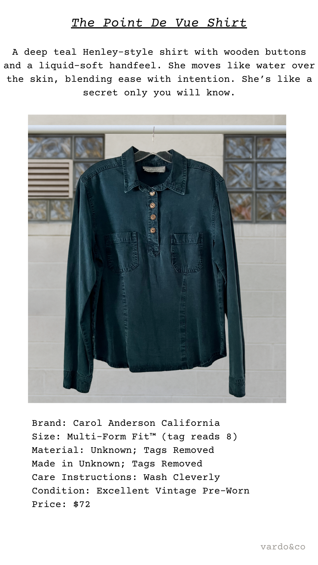 Dark teal Henley-style shirt with wooden buttons on a hanger against a tiled wall.