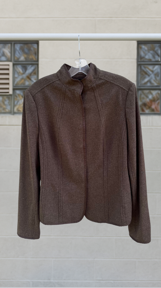 Dark ash-brown vintage wool-blend jacket with a stand collar, minimal seams, and sleek silhouette hanging on a hanger.