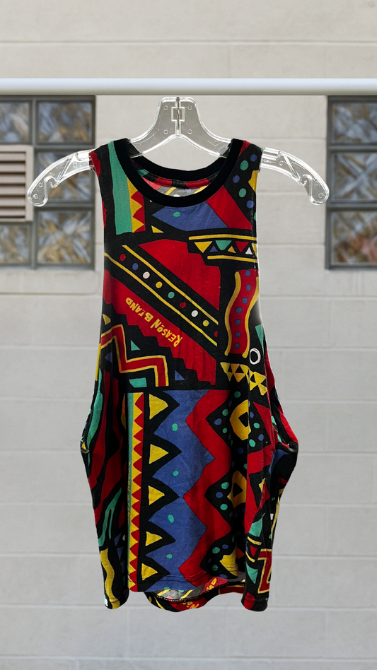 Colorful abstract sleeveless tank with drop armholes and bold geometric pattern, hanging on a clear hanger.