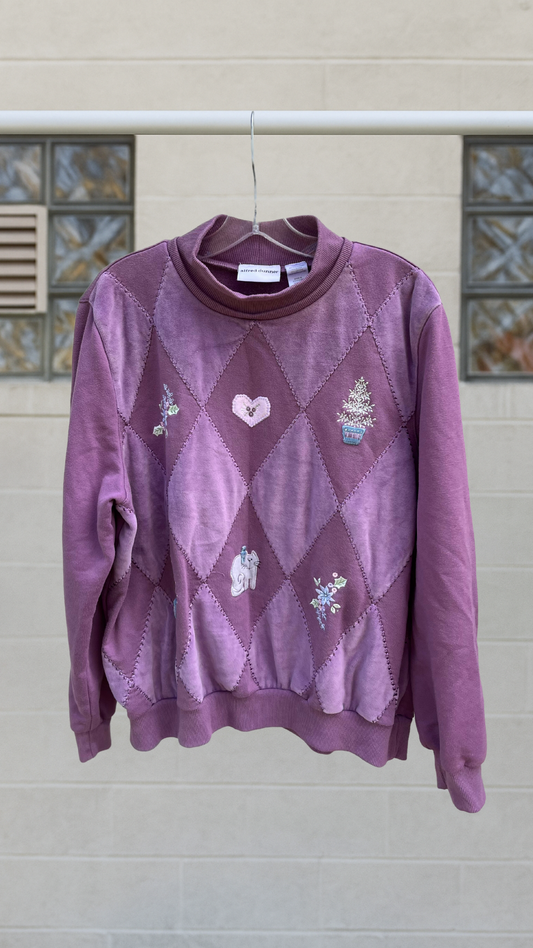 A plum purple vintage sweatshirt with diamond patchwork and whimsical embroidered motifs including a cat, heart, and potted tree